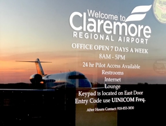 Door of the Claremore Regional Airport with plane in the background